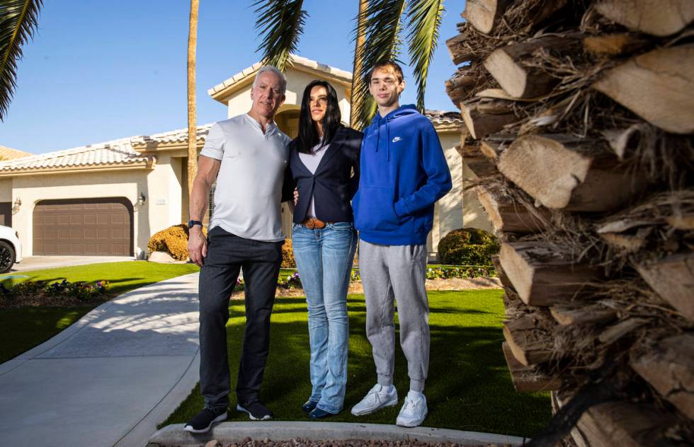 Danielle Wood, center, poses with her husband, Brian, and son, Nate, 17, at their home in Las V ...