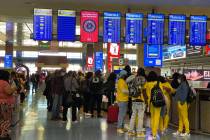 Travelers wait near baggage carousels in Terminal 1 at McCarran International Airport Wednesday ...
