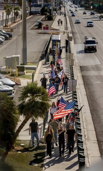 A small group walks past the Tropicana during a Veterans Day march to peacefully protest Govern ...