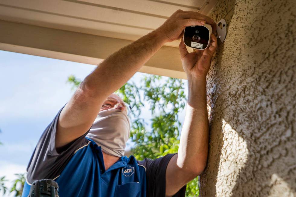 ADT Custom Home Services field service technician Paul Keplinger installs an outdoor security c ...