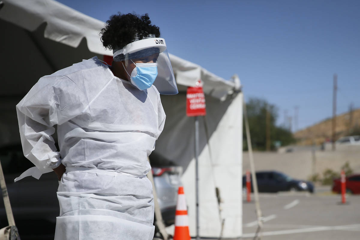 In this Oct. 26,2020, file photo, a medical worker stands at a COVID-19 state drive-thru testin ...