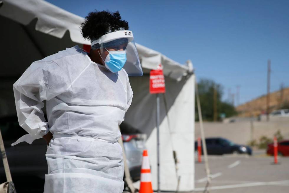 In this Oct. 26,2020, file photo, a medical worker stands at a COVID-19 state drive-thru testin ...
