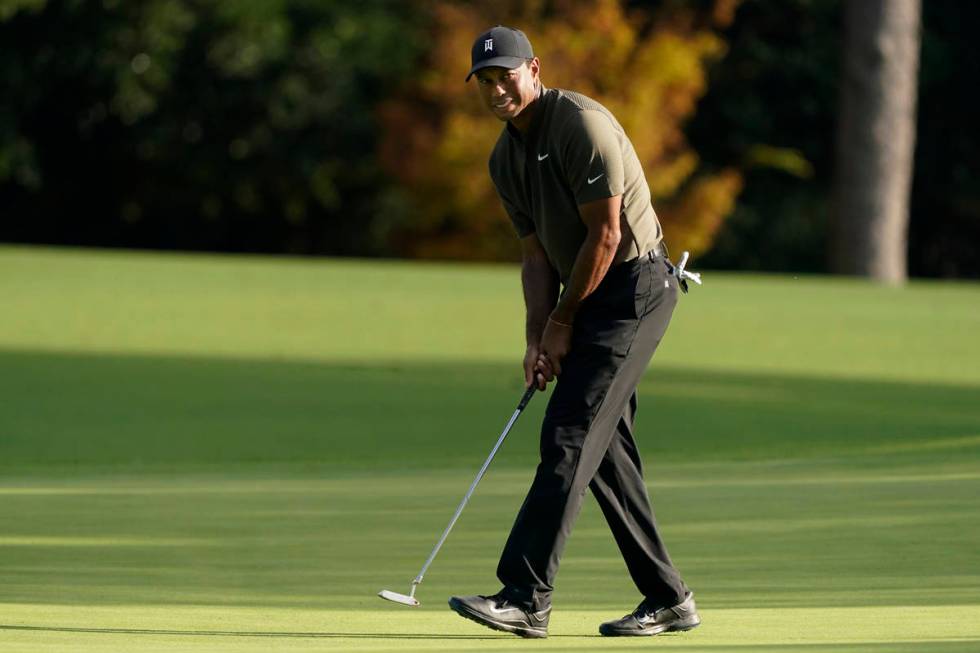Tiger Woods watches his ball as he misses a birdie putt on the eighth hole during the first rou ...