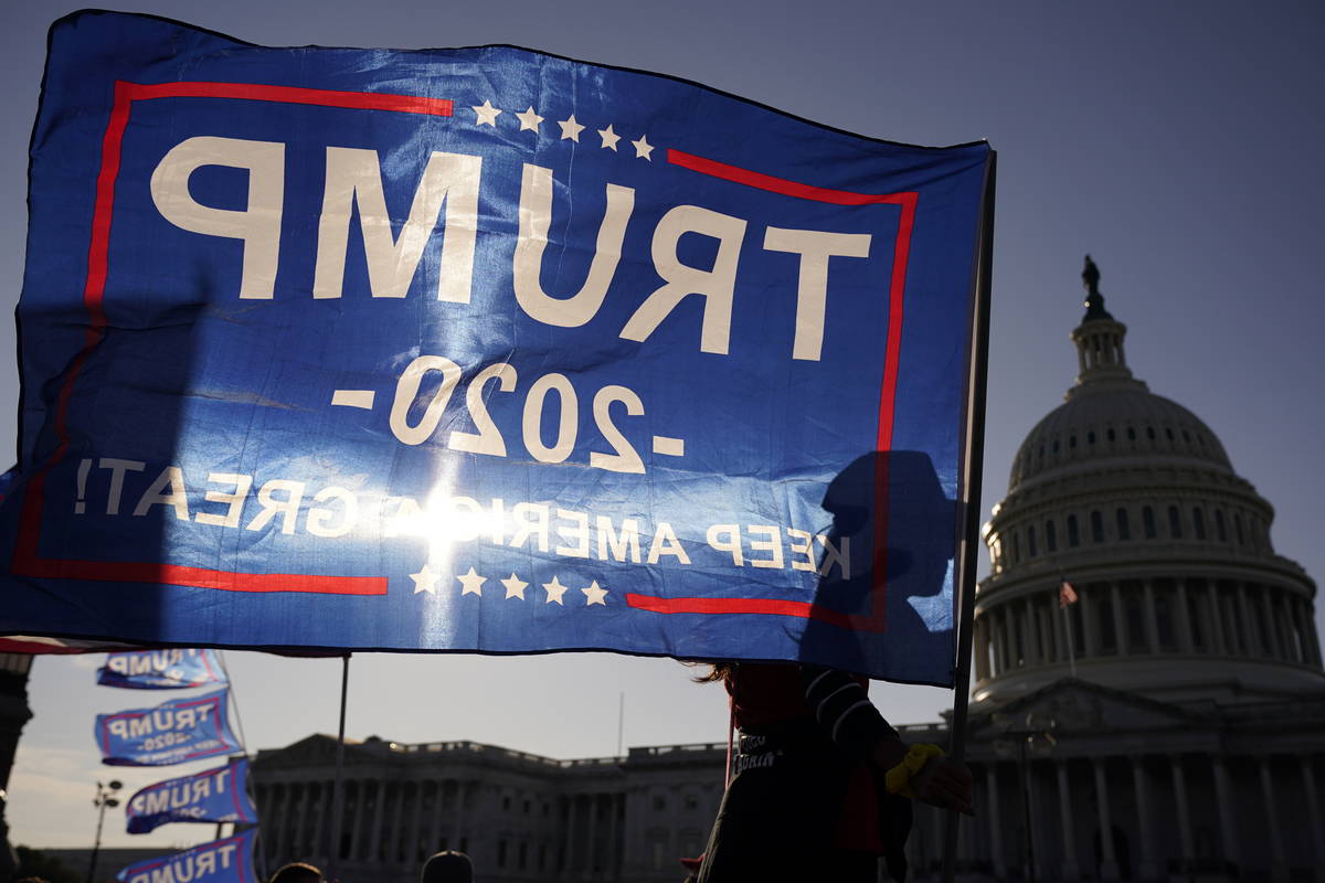 A supporter of President Donald Trump holds a Trump 2020 flag outside the U.S. Capitol building ...