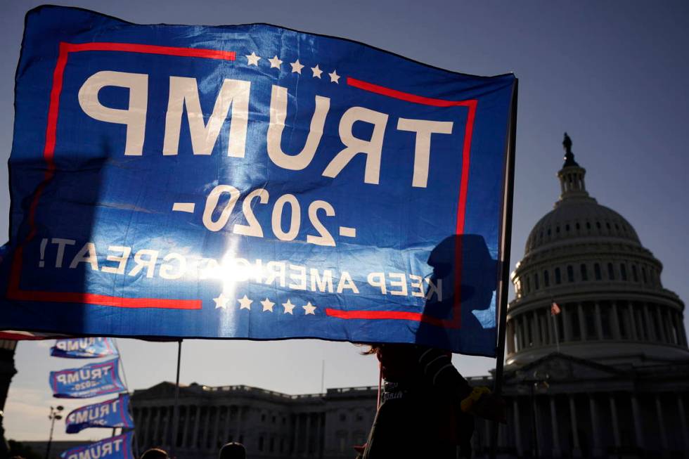 A supporter of President Donald Trump holds a Trump 2020 flag outside the U.S. Capitol building ...