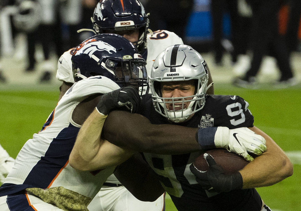 Las Vegas Raiders defensive end Carl Nassib (94) tries to avoid a tackle from Denver Broncos ce ...