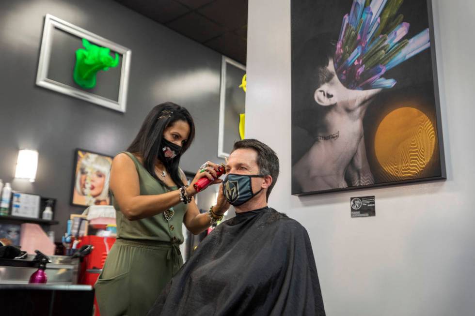 Stylist and creative director of Revolution Salon Lilia Dryer gives a hair cut to Mike Longi, 5 ...