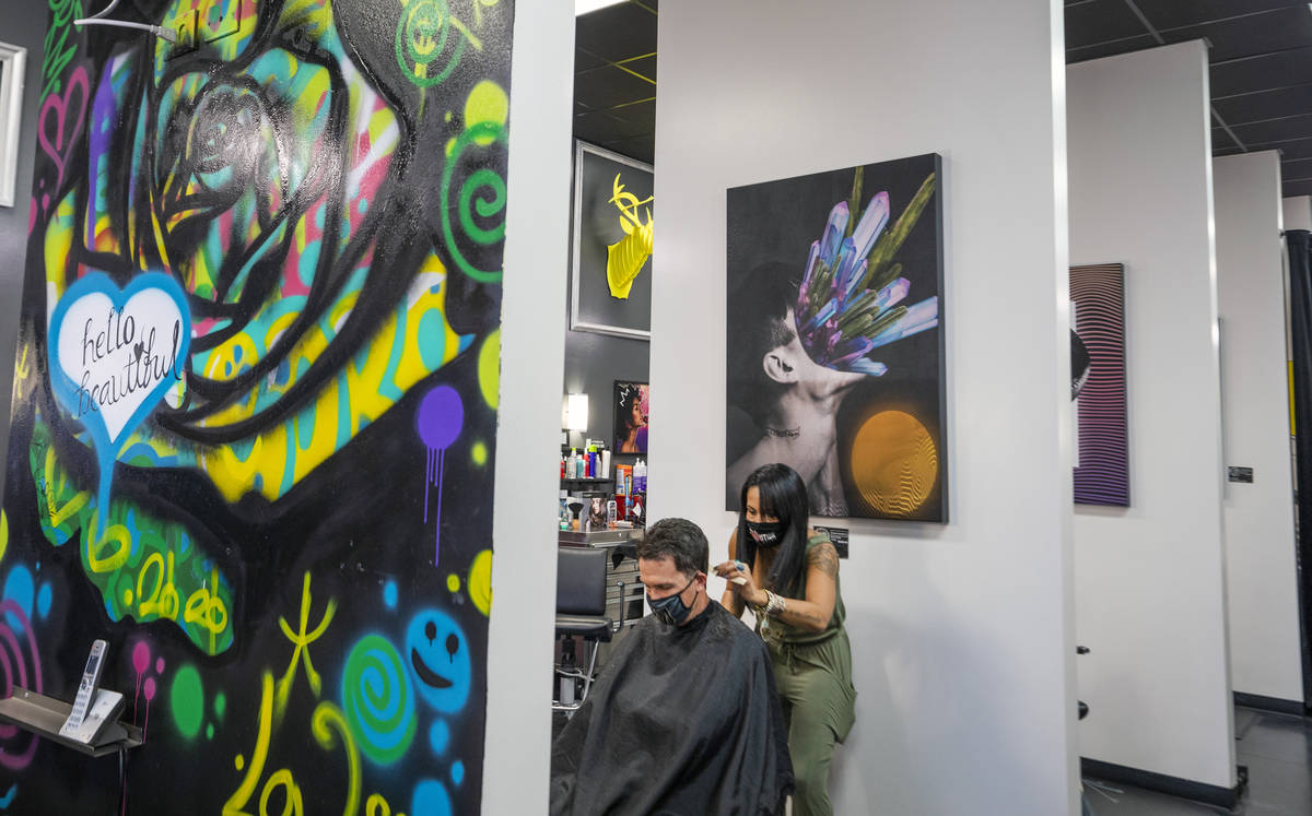 Client Mike Longi, 56, of Las Vegas, receives a hair cut by stylist and creative director of Re ...