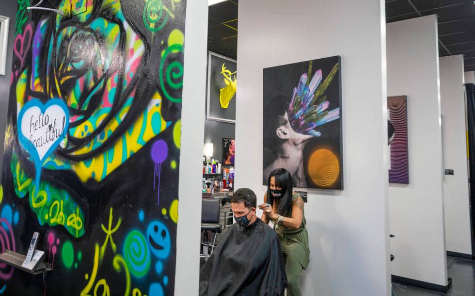 Client Mike Longi, 56, of Las Vegas, receives a hair cut by stylist and creative director of Re ...