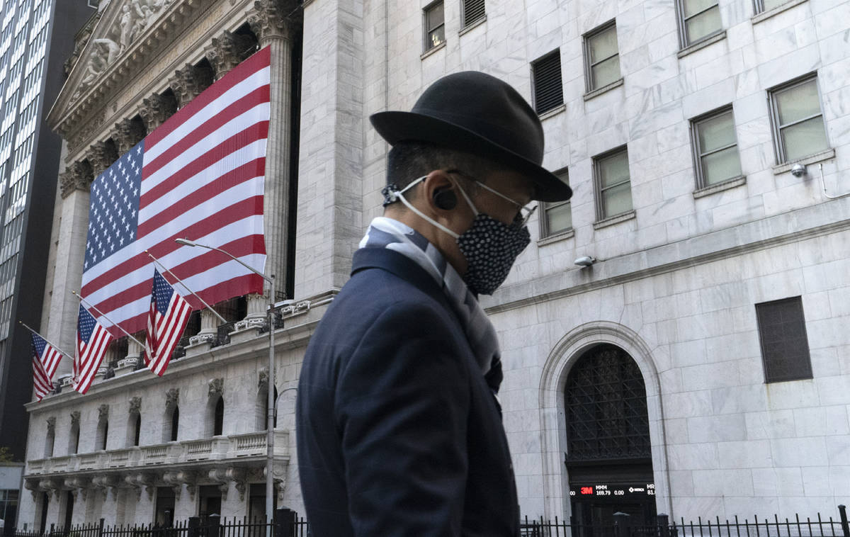 A man wearing a mask passes the New York Stock Exchange, Monday, Nov. 16, 2020, in New York. St ...