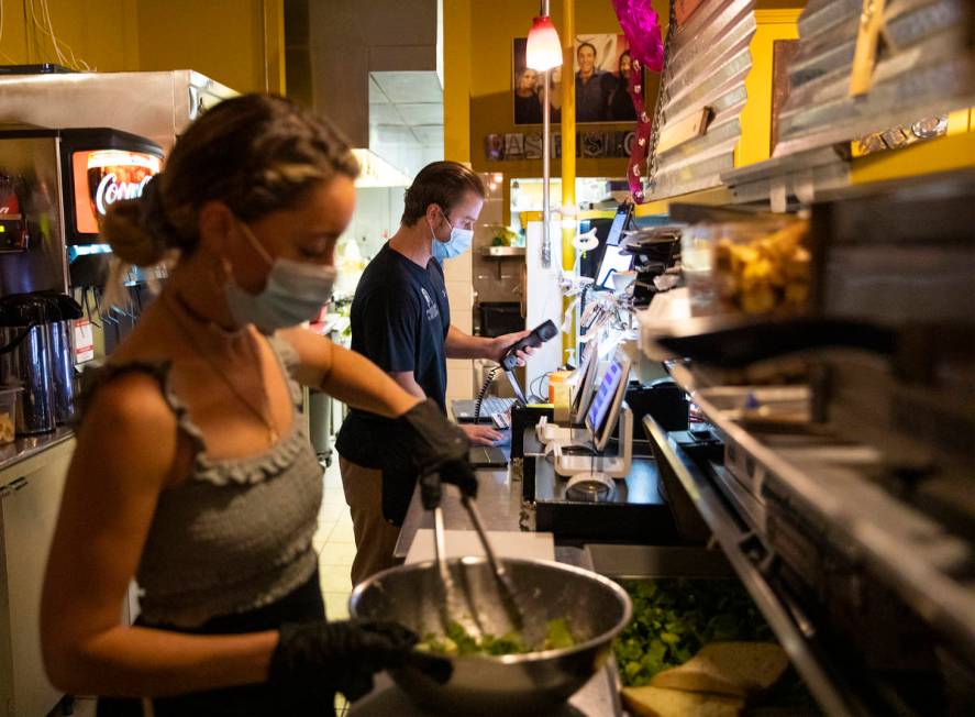 Bianca Alenik, left, prepares a salad as Dakota Wadkins, right, takes a phone order at Pasta Sh ...