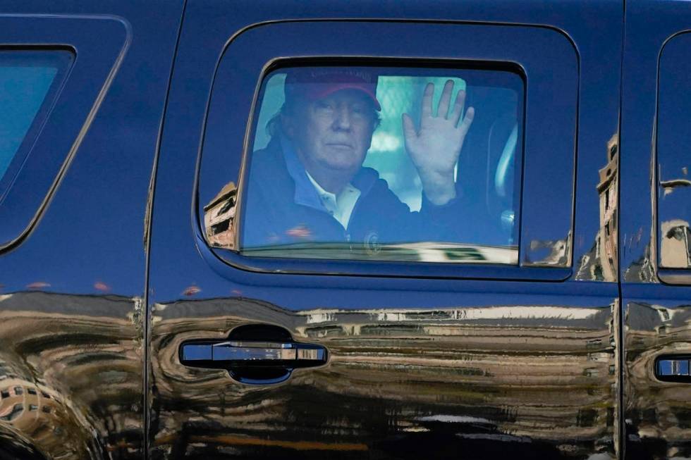 President Donald Trump waves to supporters from his motorcade as people gather for a march Satu ...