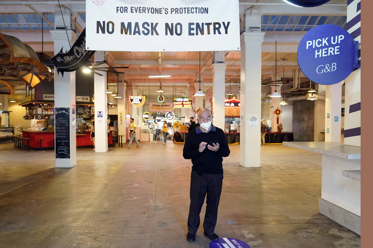 FILE - In this Nov. 16, 2020, file photo, a sign points to a mask mandate at the Grand Central ...
