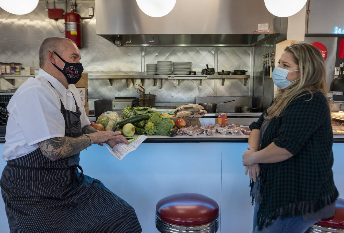 Chef Johnny Church, left, and Katinka Fresinski, founder of 24Meals, look over the rules of usi ...