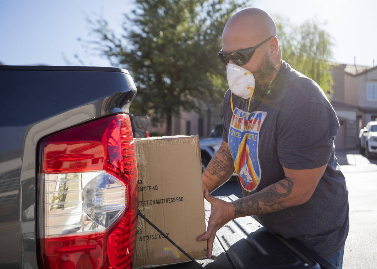 24Meals volunteer driver Anthony Magana loads meals created by chef Johnny Church into his truc ...