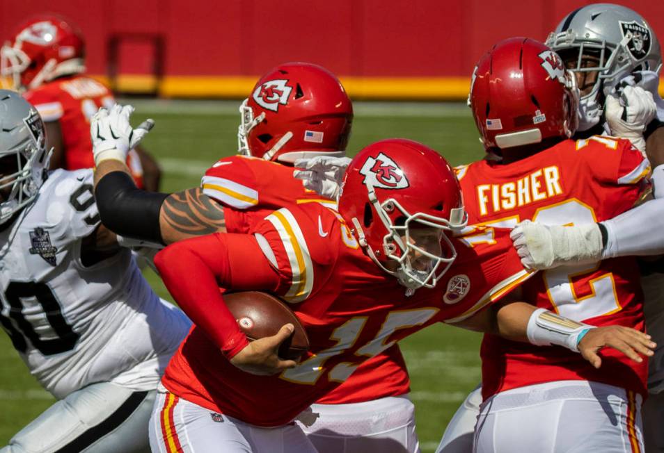 Kansas City Chiefs quarterback Patrick Mahomes (15) tries to scramble away from Las Vegas Raide ...