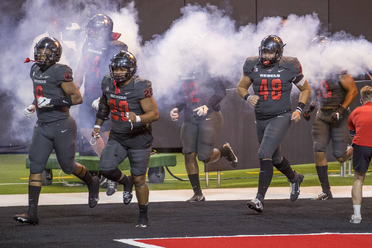 UNLV Rebels players take the field to face the Nevada Wolf Pack before the first half of their ...
