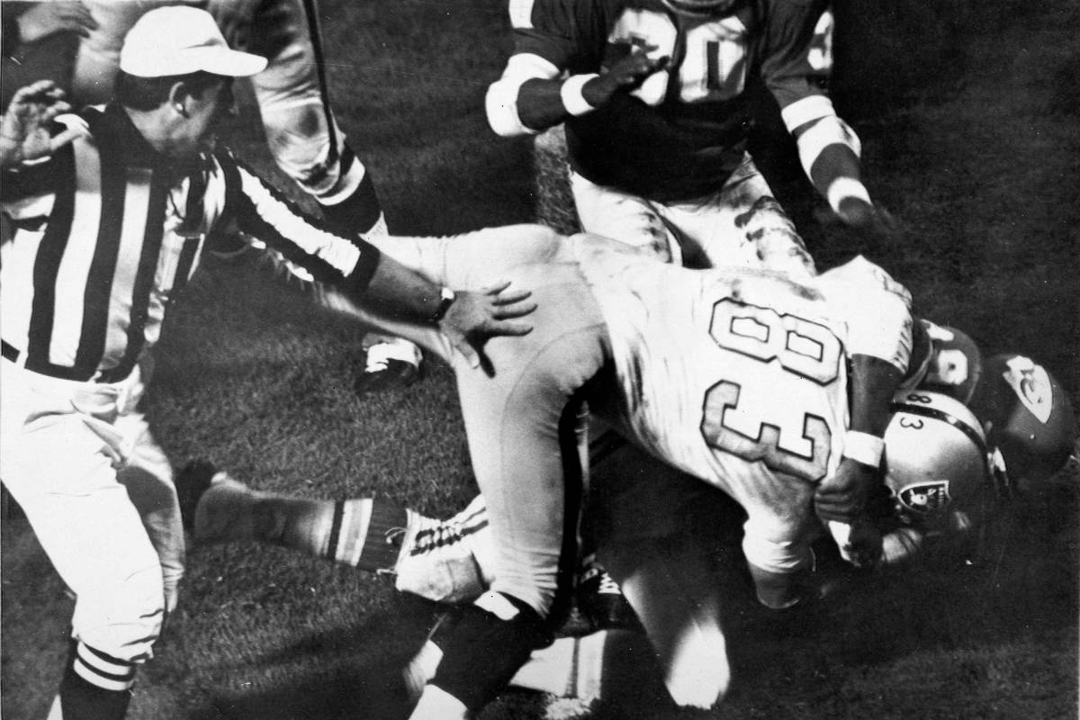 Otis Taylor of the Kansas City Chiefs, underneath, grabs Ben Davidson, on top, of the Oakland R ...