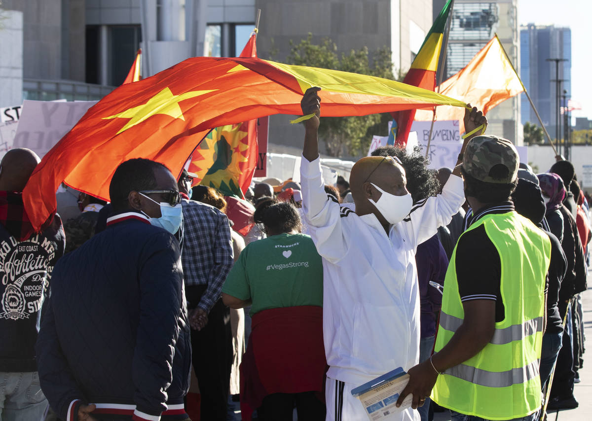 Gebrekidan Desita, center, holds a flag of Tigray outside of the Lloyd D. George Federal Courth ...