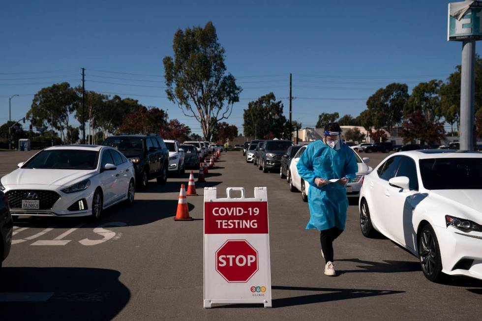 FILE - In this Nov. 16, 2020, file photo, student nurse Ryan Eachus collects forms as cars line ...