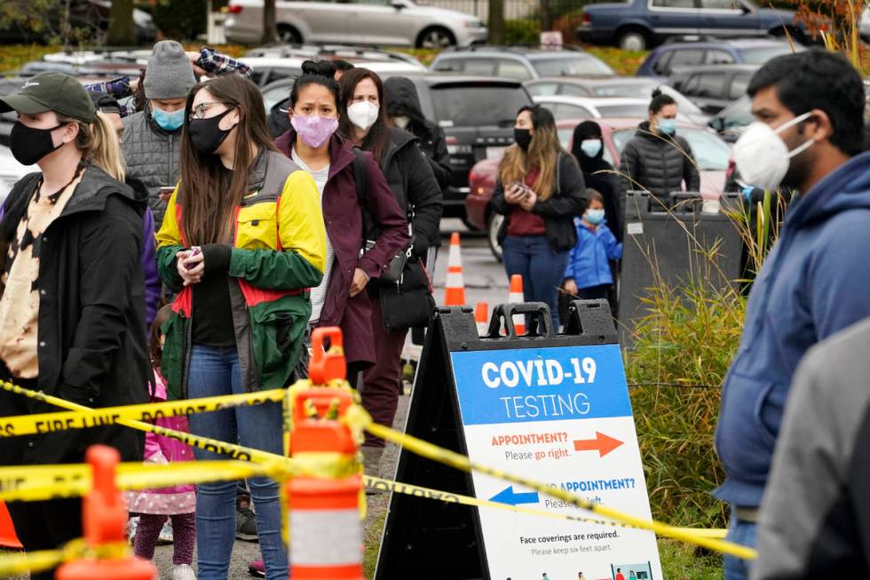 FILE - In this Nov. 18, 2020, file photo, people line up to be tested for the coronavirus at a ...