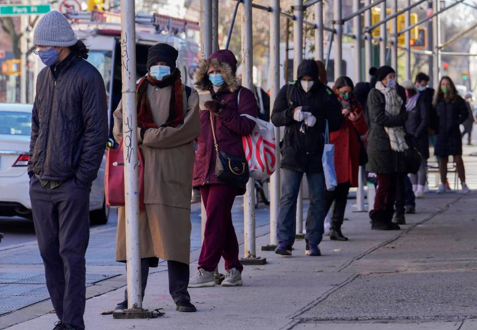 FILE - In this Nov. 18, 2020, file photo, people wait in a line stretching around a block, outs ...