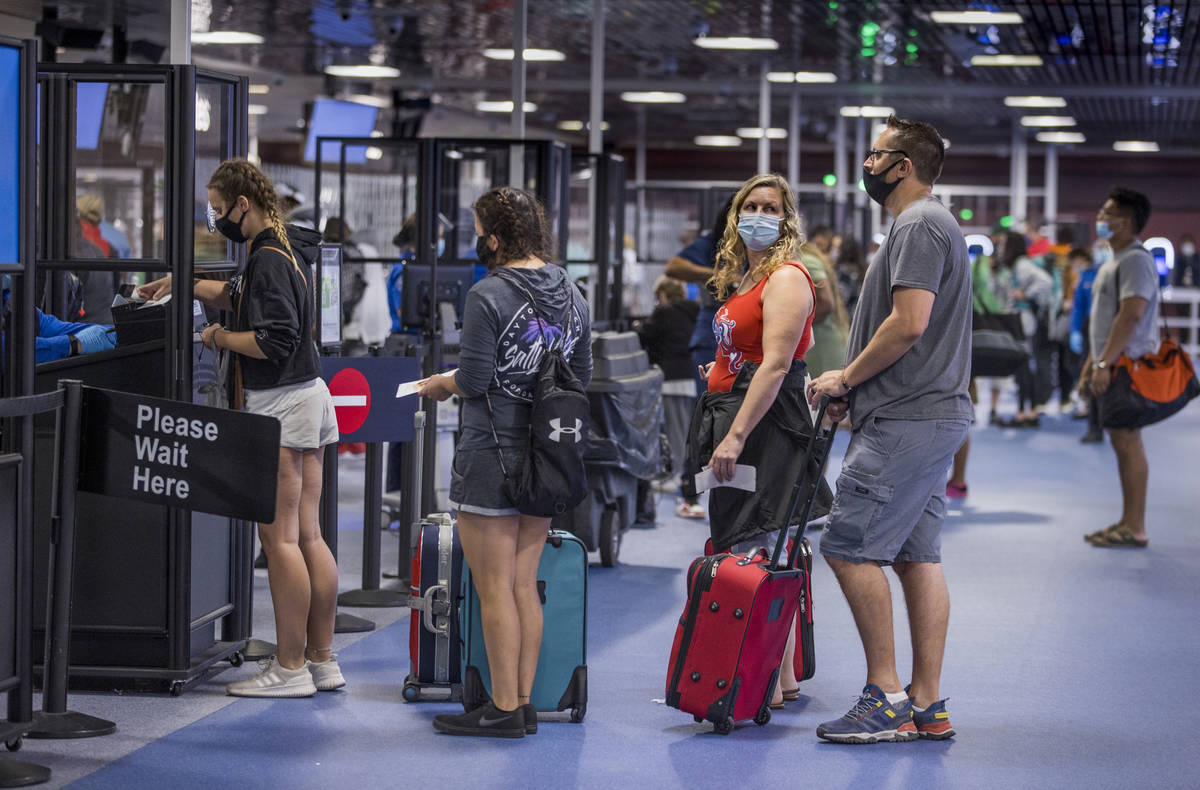 Passengers make their way through the TSA checkpoint in Terminal 1 as COVID-19 safety precautio ...