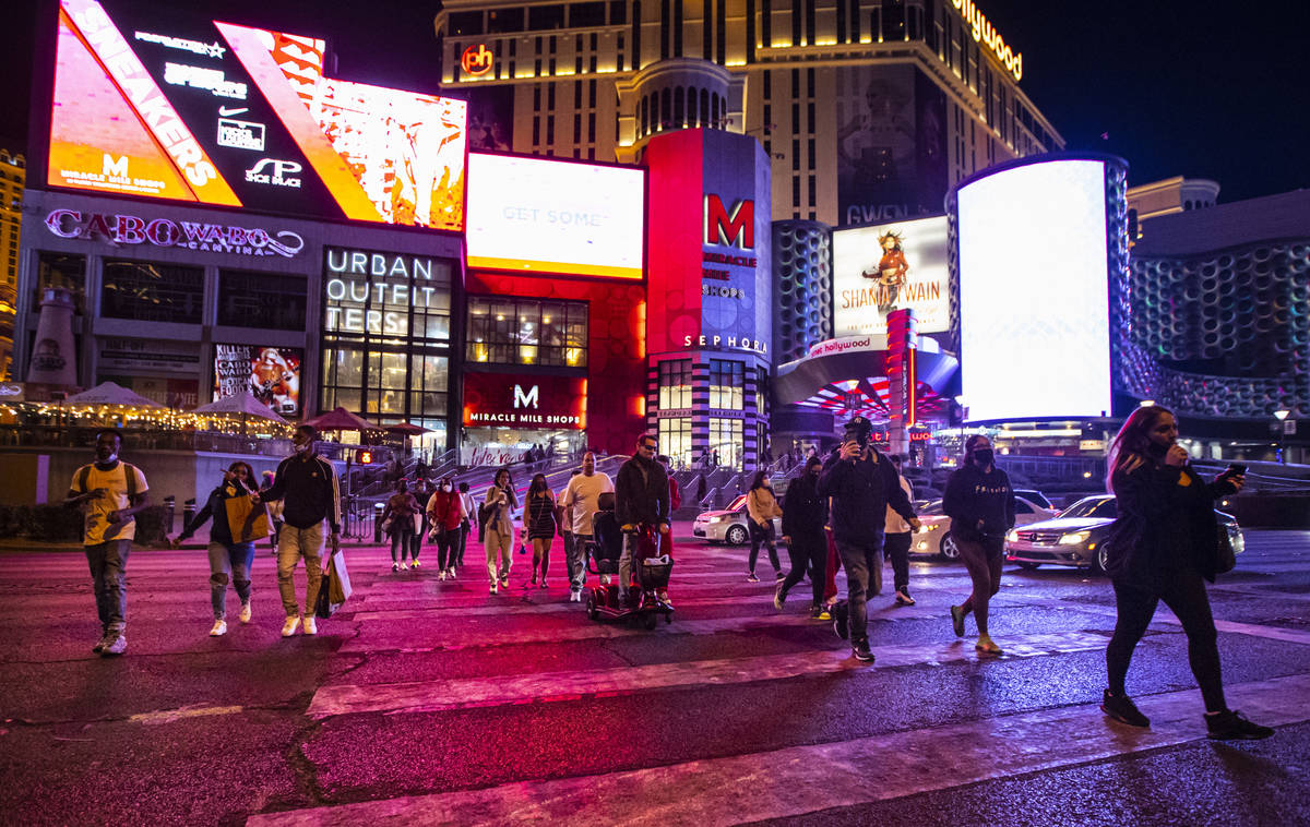 People walk along a crosswalk outside of the Miracle Mile Shops on the Las Vegas Strip Thursday ...