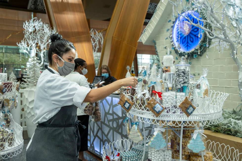 Aria's assistant pastry chef Andrea Madrid arranges treats in the retail area during the unveil ...