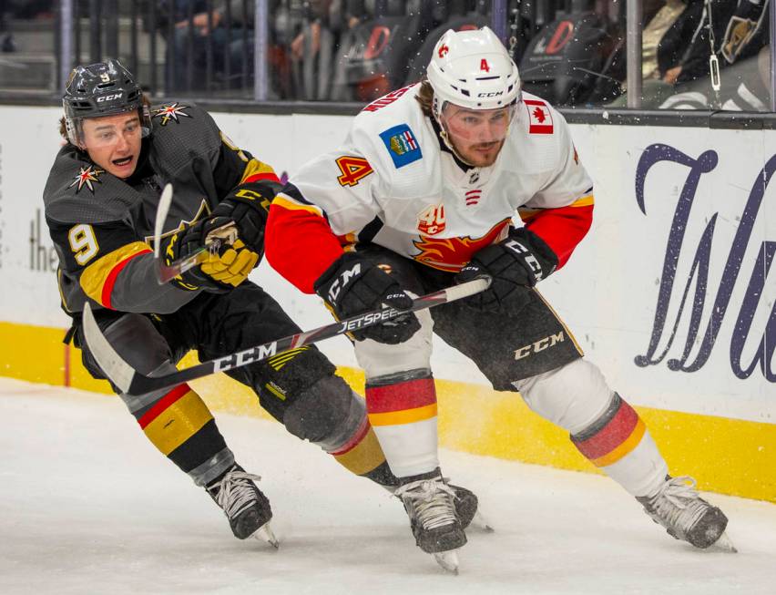 Vegas Golden Knights center Cody Glass (9, left) battles on the ice with Calgary Flames defense ...