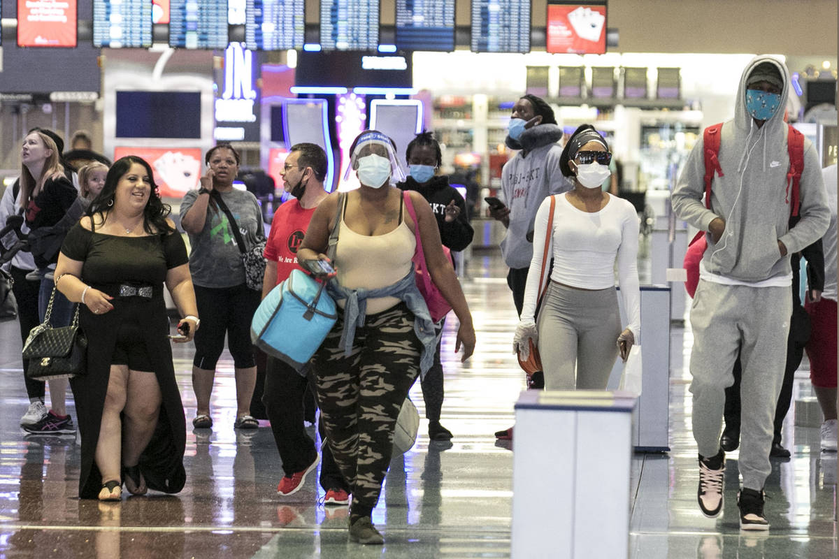 Arriving passengers head toward a baggage claim area at McCarran International Airport on Thurs ...