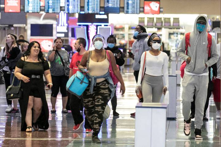 Arriving passengers head toward a baggage claim area at McCarran International Airport on Thurs ...