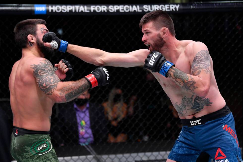 (R-L) Tim Means punches Mike Perry in their welterweight bout during the UFC 255 event at UFC A ...