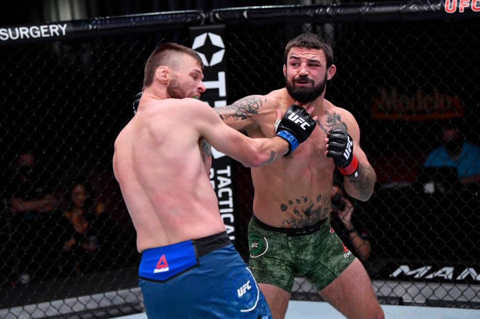 (R-L) Mike Perry punches Tim Means in their welterweight bout during the UFC 255 event at UFC A ...