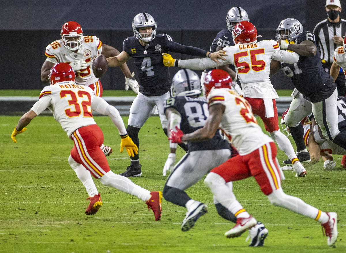 Las Vegas Raiders quarterback Derek Carr (4) is under heavy pressure while looking for a pass b ...