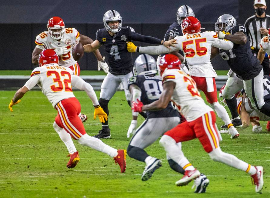 Las Vegas Raiders quarterback Derek Carr (4) is under heavy pressure while looking for a pass b ...