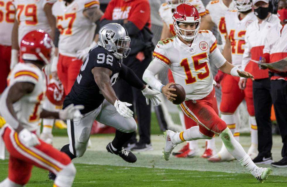 Kansas City Chiefs quarterback Patrick Mahomes (15) scrambles past Las Vegas Raiders defensive ...