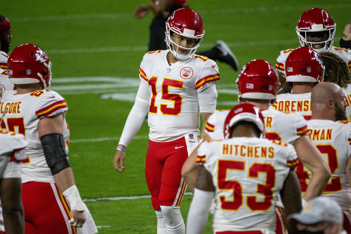 Kansas City Chiefs quarterback Patrick Mahomes (15) talks to his teammates before an NFL footba ...