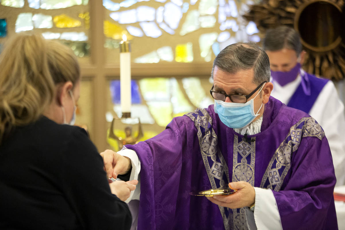 Jennifer Berelowitz, receives communion from Msgr. Gregory Gordon during a virtual Mass at the ...