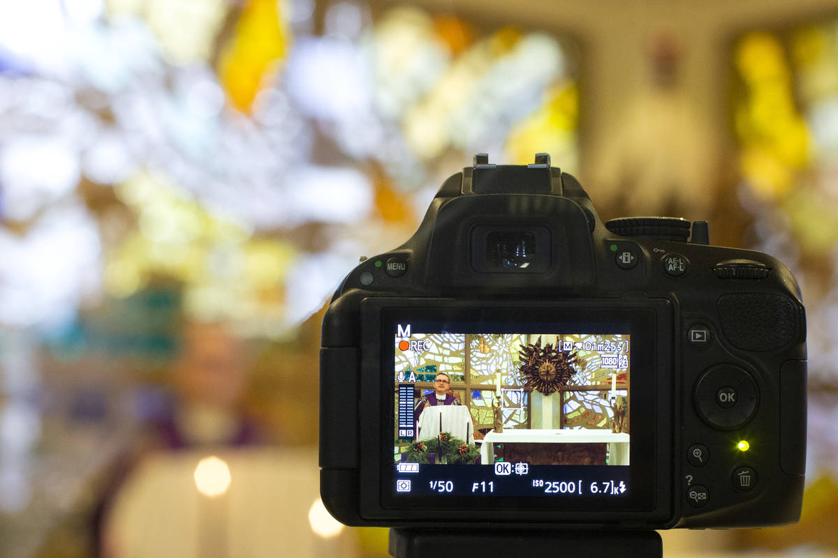 A camera records Msgr. Gregory Gordon giving a virtual Mass at the The Roman Catholic Diocese o ...