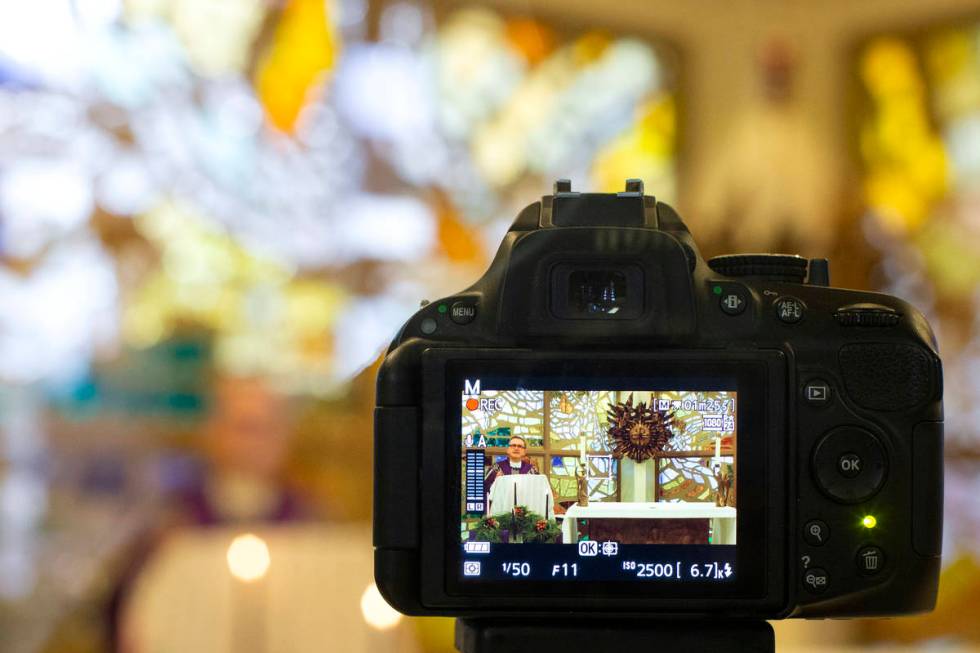 A camera records Msgr. Gregory Gordon giving a virtual Mass at the The Roman Catholic Diocese o ...