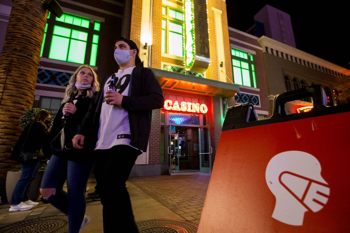 Some visitors to The LINQ Promenade wore masks while others didn't as signs asked them to on Su ...
