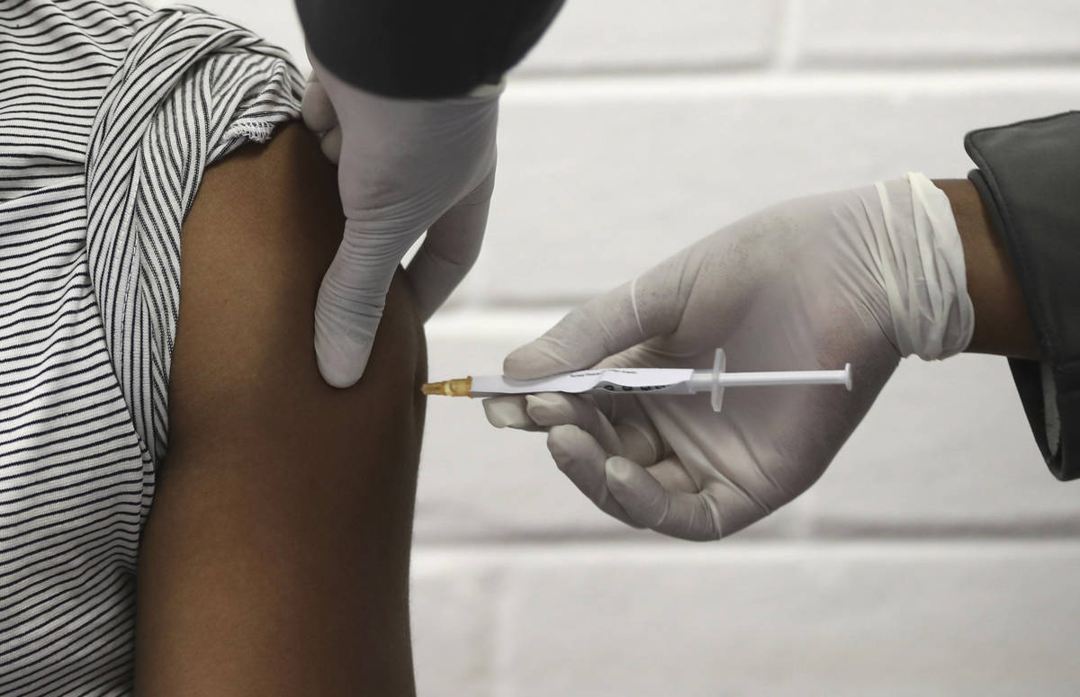 In this Wednesday, June 24, 2020, file photo, a volunteer receives an injection at the Chris Ha ...