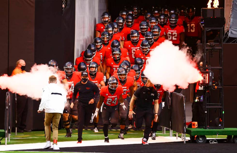 UNLV Rebels players run onto the field before taking on the Wyoming Cowboys in a football game ...