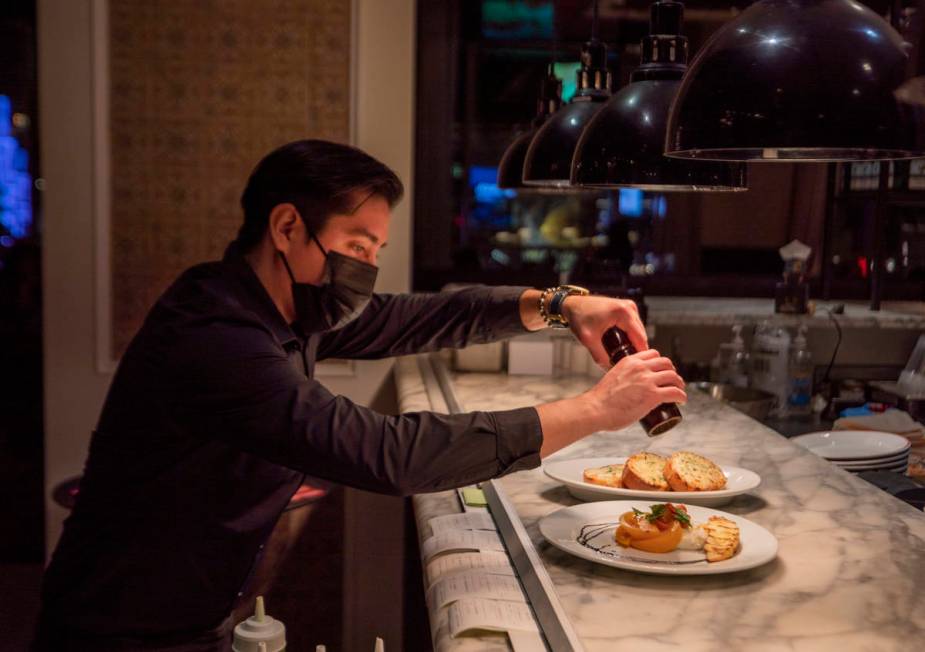 Server Alex Romero puts the final touches on dishes at Buddy V's Ristorante at The Venetian the ...