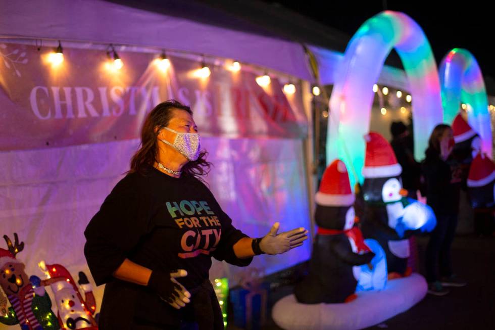 Volunteer Janice Heard dances to Christmas music and cheers for passing cars at Hope for the Ci ...