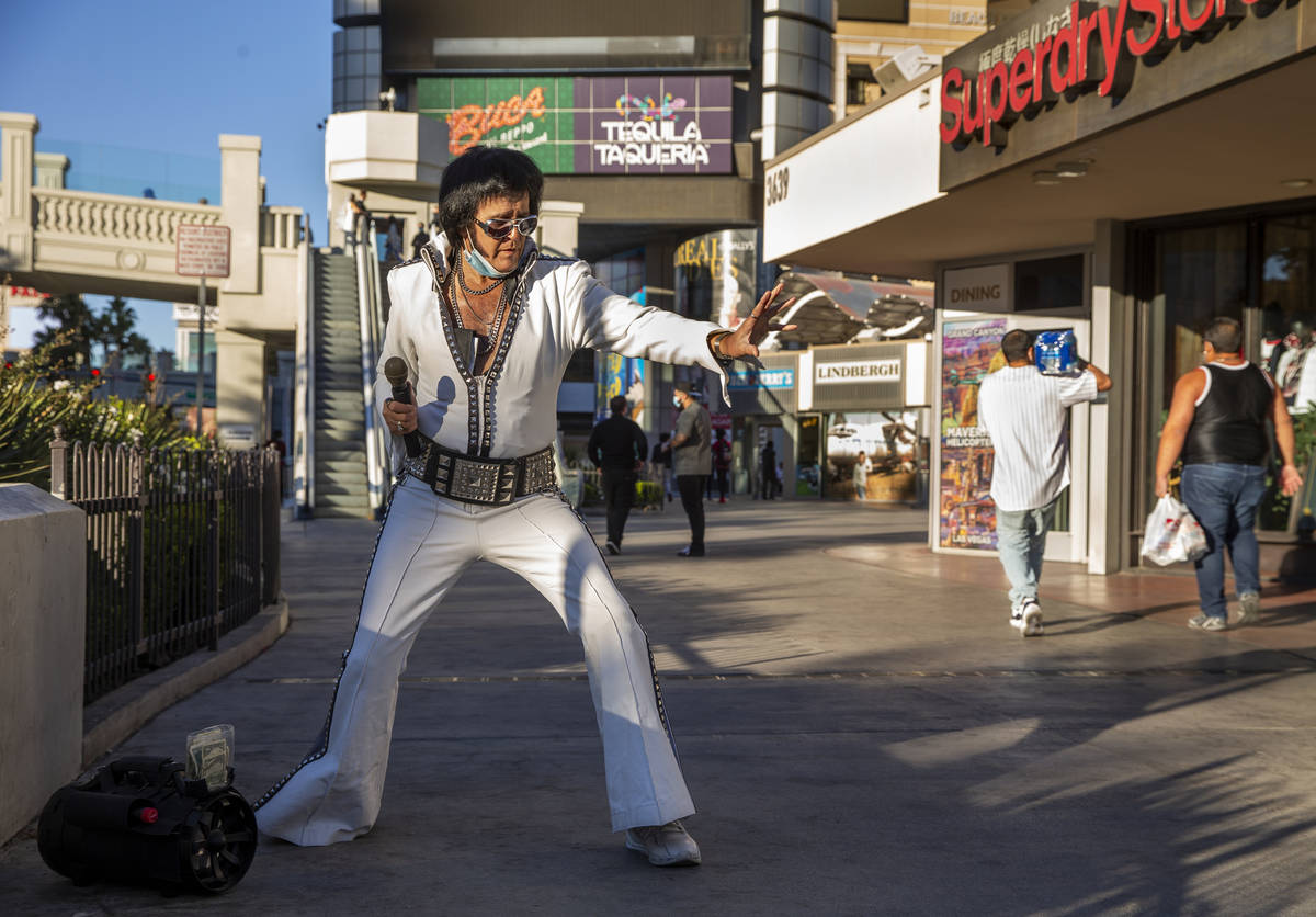 An Elvis impersonator drums up a little street business along the Las Vegas Strip on Tuesday, N ...