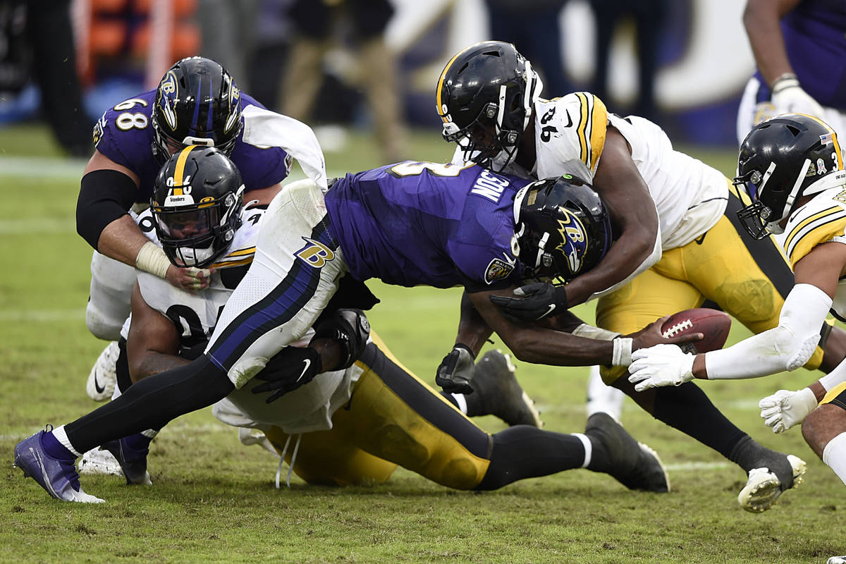 Baltimore Ravens quarterback Lamar Jackson is tackled by Pittsburgh Steelers Isaiah Buggs durin ...