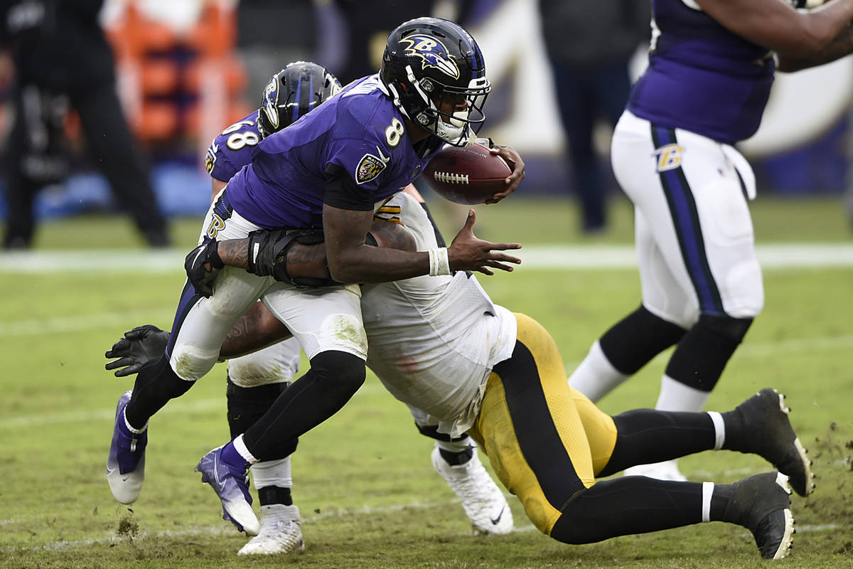 Baltimore Ravens quarterback Lamar Jackson is tackled by Pittsburgh Steelers Isaiah Buggs durin ...