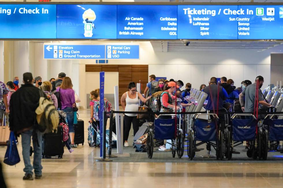 Holiday travelers check in at kiosks near an airline counter at Orlando International Airport T ...